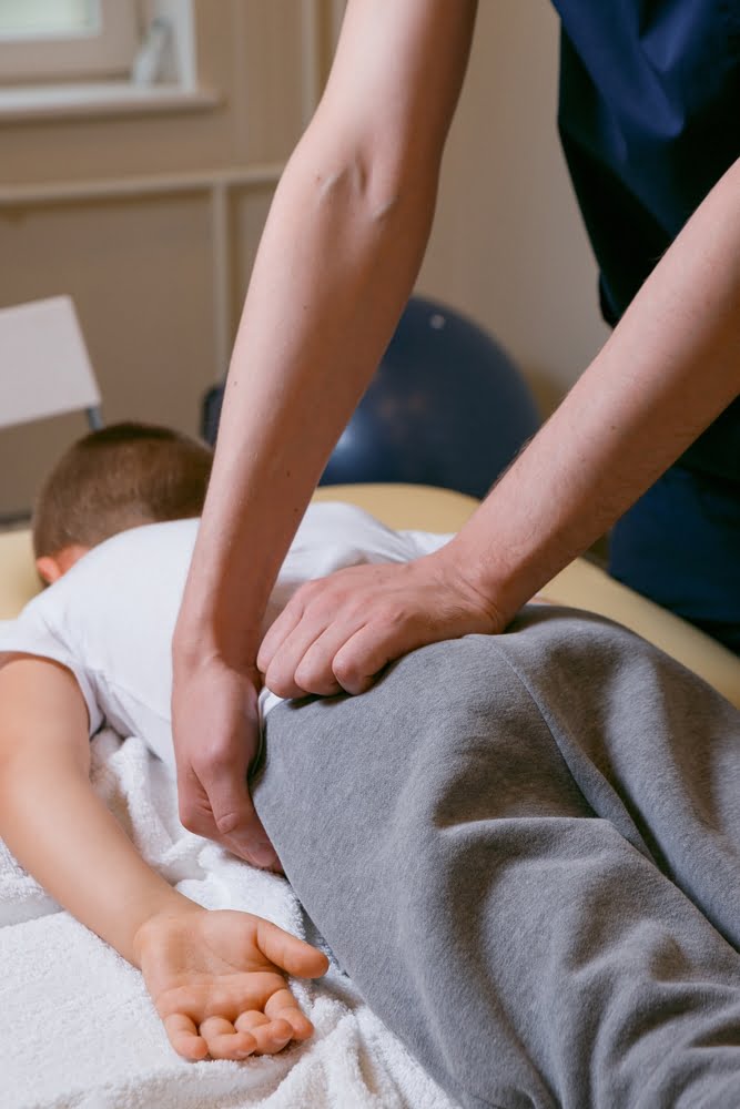 A chiropractor performing a spinal adjustment on a patient lying face down on a treatment table - Chiropractor Brunswick GA A chiropractor performing a spinal adjustment on a patient lying face down on a treatment table - Chiropractor Brunswick GA