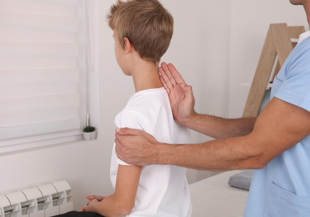 A chiropractor carefully examines a child’s posture and spinal alignment, supporting healthy growth, balance, and mobility through gentle care – Waynesville Chiropractor