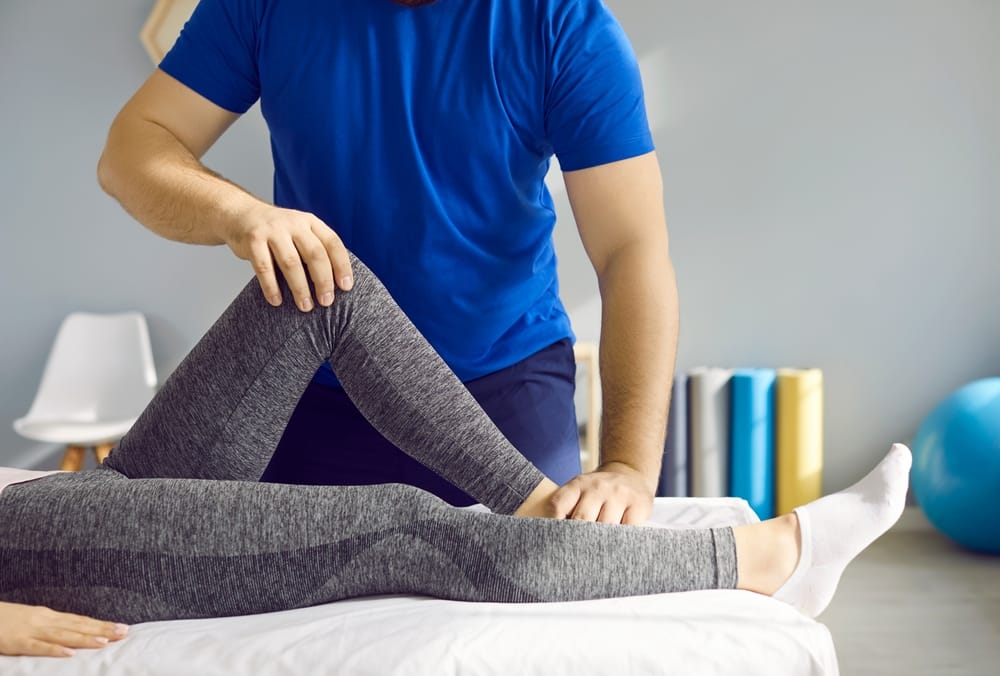 A therapist assists with guided leg and hip mobility therapy to improve flexibility, reduce discomfort, and promote functional movement recovery – Pain Management Brunswick GA