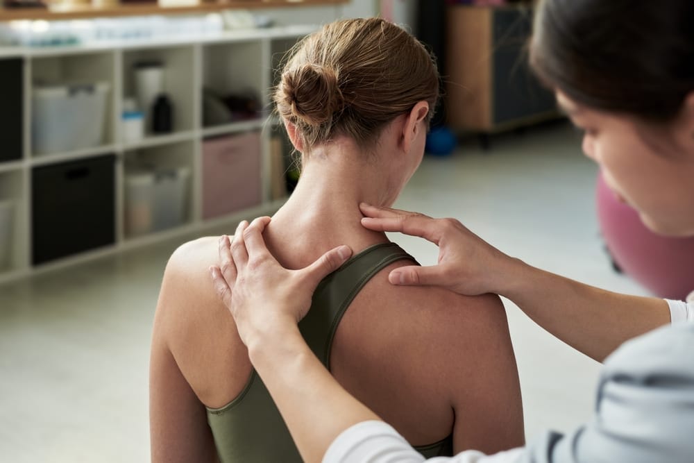 A chiropractor performs a gentle neck and shoulder assessment to evaluate posture, alignment, and muscle tension as part of personalized care – Waynesville Chiropractor